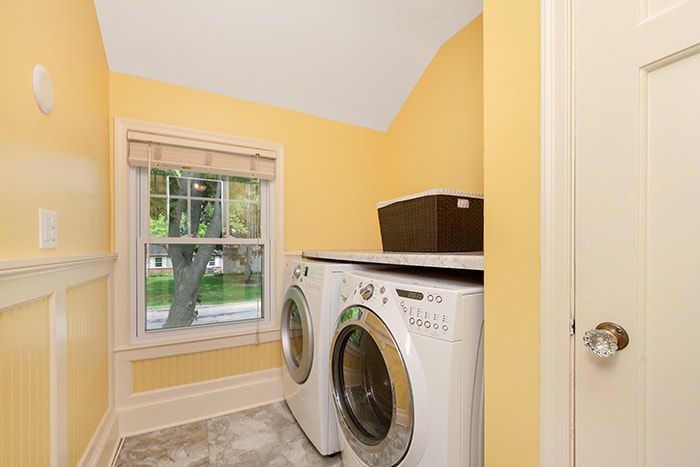 A laundry room with a washer and dryer and a window.