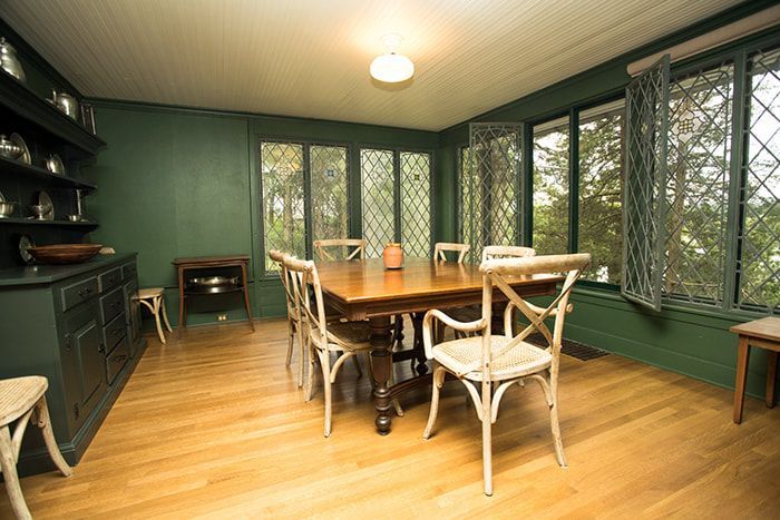 A dining room with a table and chairs and green walls