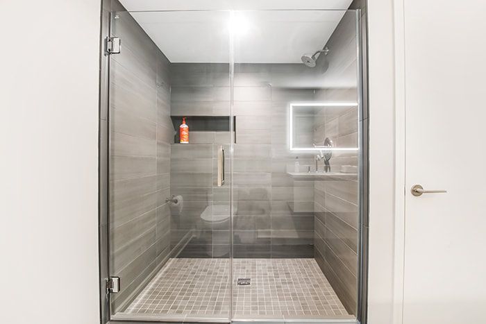 A bathroom with a walk in shower and a toilet.