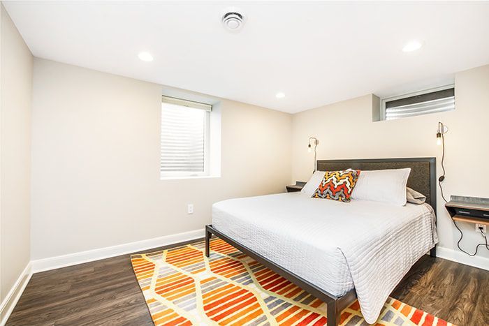 A bedroom with a king size bed and a rug.