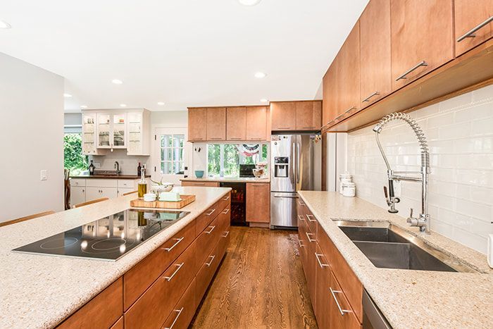 A kitchen with wooden cabinets , granite counter tops , stainless steel appliances and a large island.