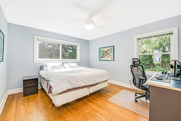 A bedroom with a bed , desk and chair.