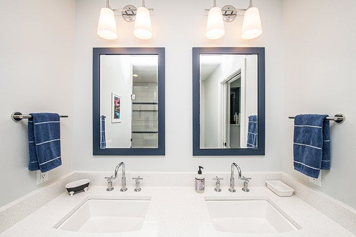 A bathroom with two sinks and two mirrors