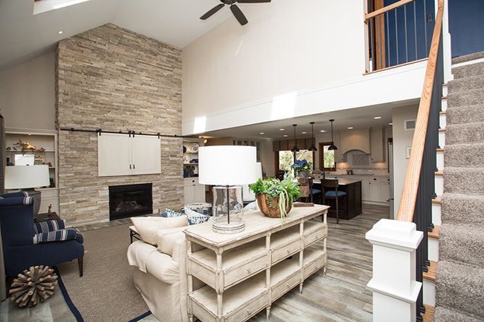 A living room with a fireplace and stairs leading up to the second floor.