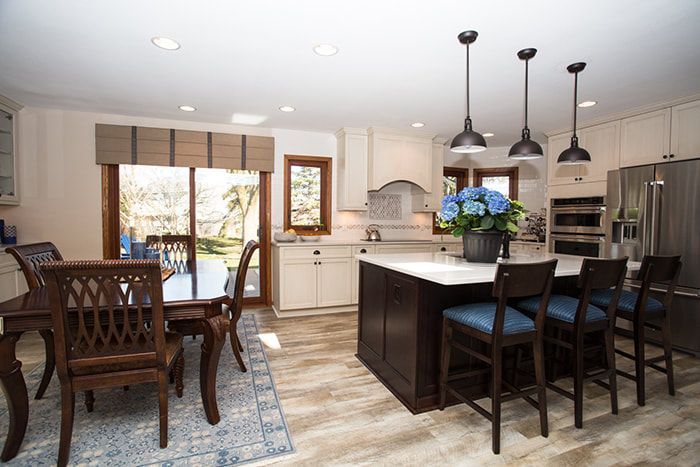 A kitchen with a table and chairs and a large island.