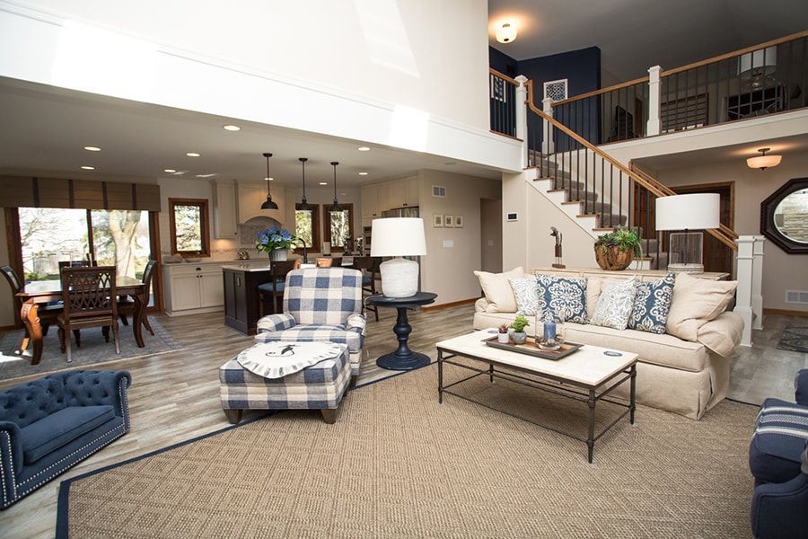 A living room with a couch , chair , coffee table and stairs.