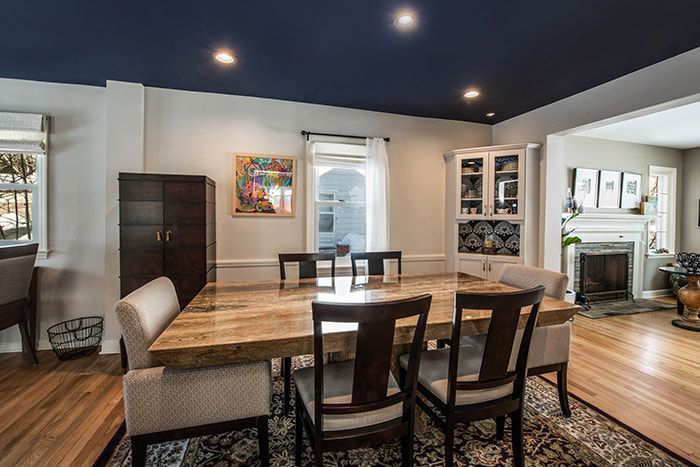 A dining room with a table and chairs and a blue ceiling