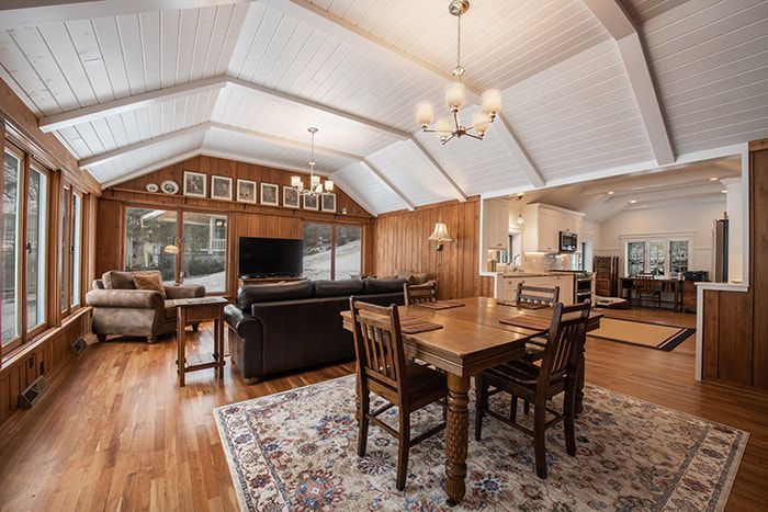 A living room with a table and chairs and a large window.
