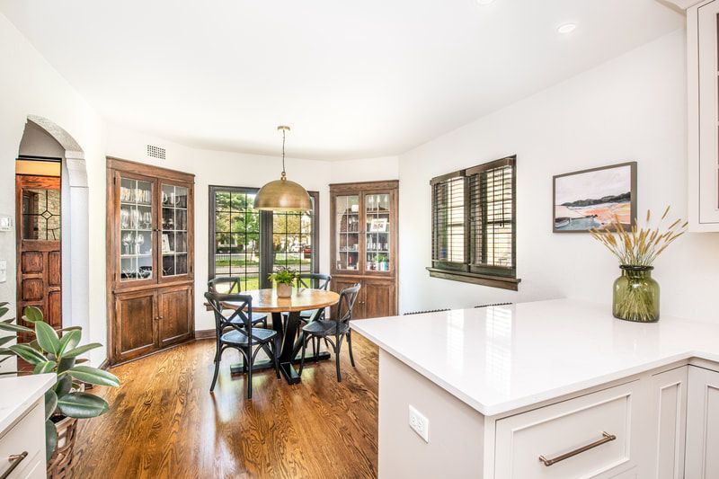 A kitchen with a table and chairs in it and a dining room.