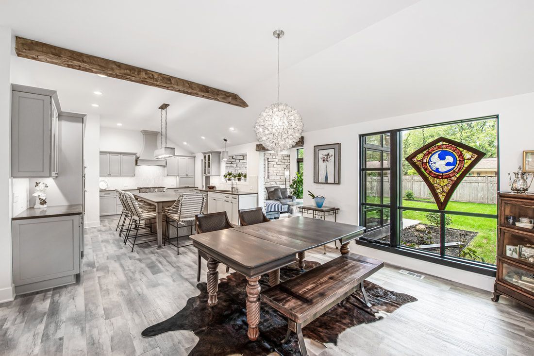A dining room with a table and chairs and a stained glass window.