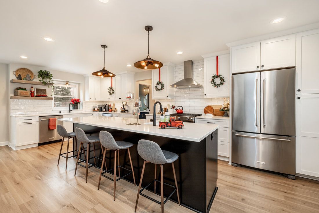 A kitchen with white cabinets and stainless steel appliances and a large island.