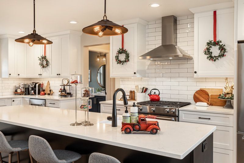 A kitchen decorated for christmas with a red truck on the counter.