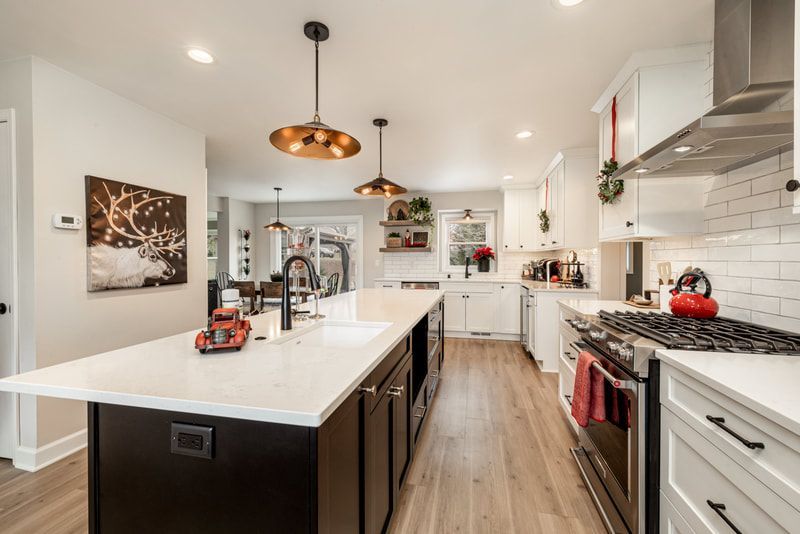 A kitchen with stainless steel appliances and a large island in the middle.