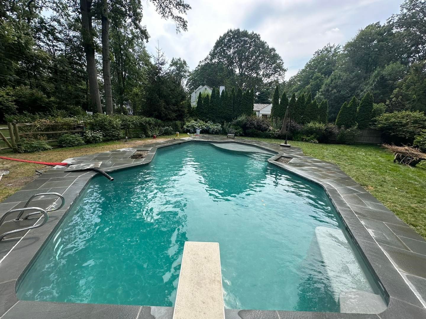 A large swimming pool with a diving board in the middle of it.