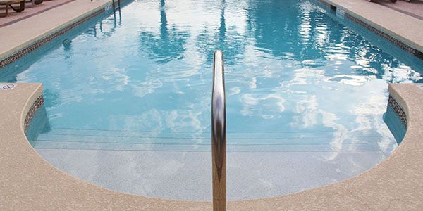 A large swimming pool with a staircase leading to it.