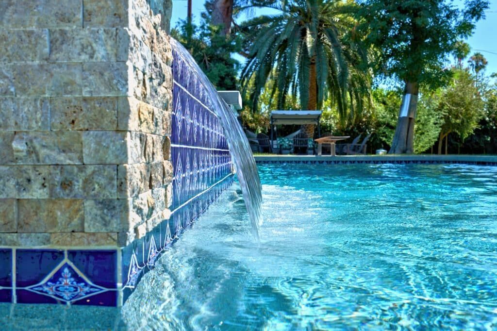 There is a waterfall in the middle of the pool.