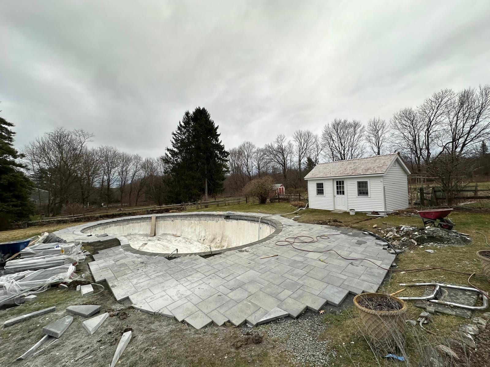 A swimming pool is being built in a backyard with a house in the background.