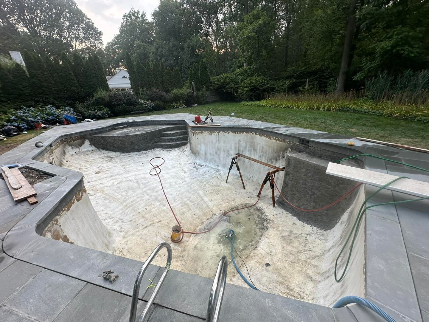 A swimming pool is being built in a backyard.