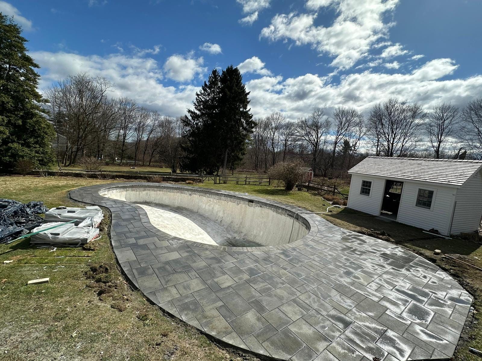 A swimming pool is being built in the backyard of a house.