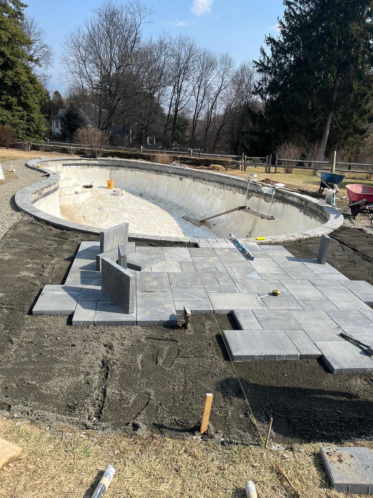 A large swimming pool is being built in a backyard.