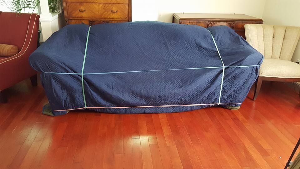 couch packed in moving blanket
