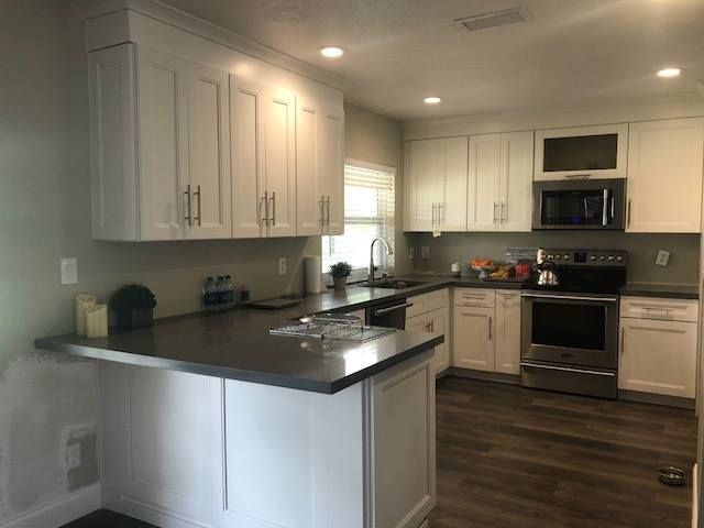 A kitchen with white cabinets and stainless steel appliances