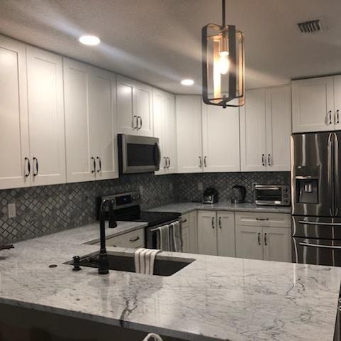 A kitchen with white cabinets and stainless steel appliances