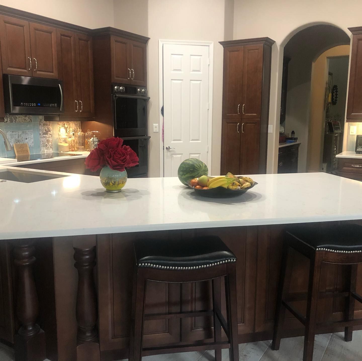 A kitchen with a bowl of fruit on the counter