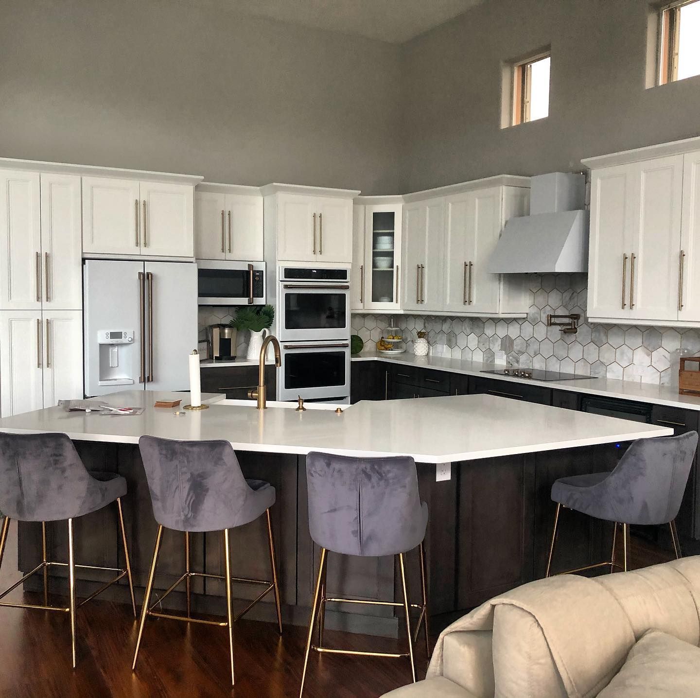 A kitchen with white cabinets and a large island