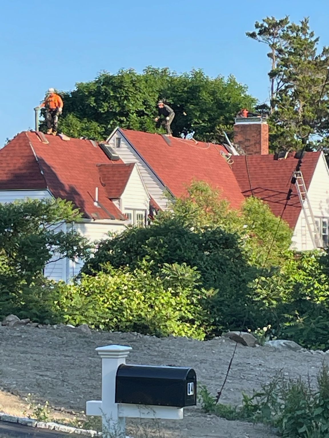 Two men are working on the roof of a house
