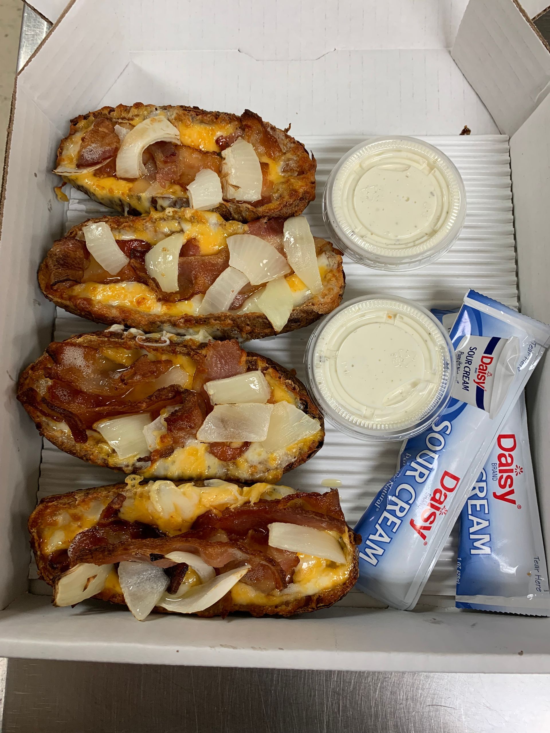 A box of potato skins with cheese bacon and sour cream