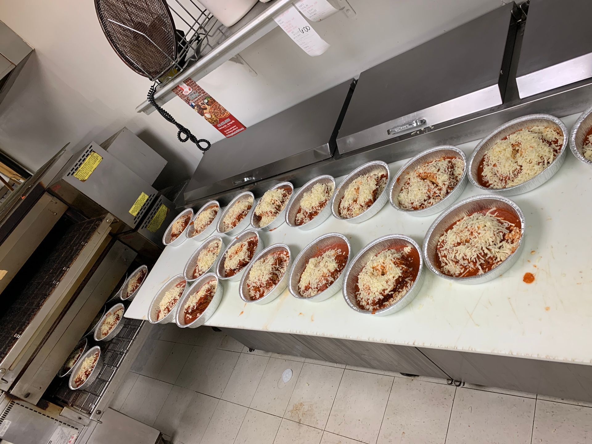 A bunch of bowls of food are sitting on a counter in a kitchen.