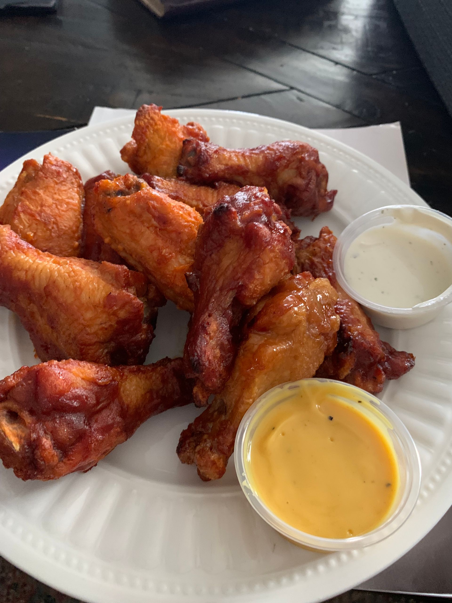 A white plate topped with chicken wings and dipping sauce