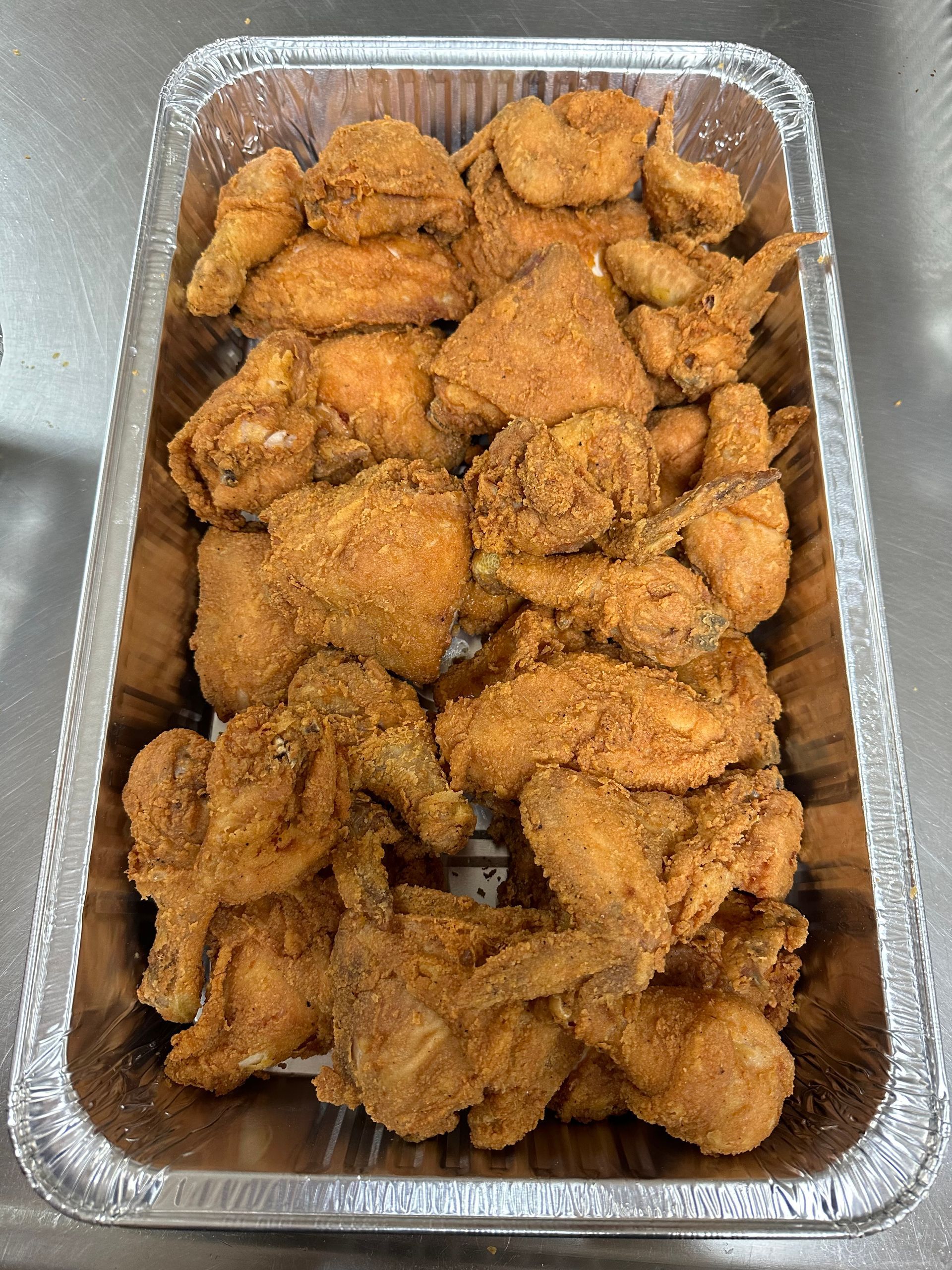 A tray of fried chicken is sitting on a counter.