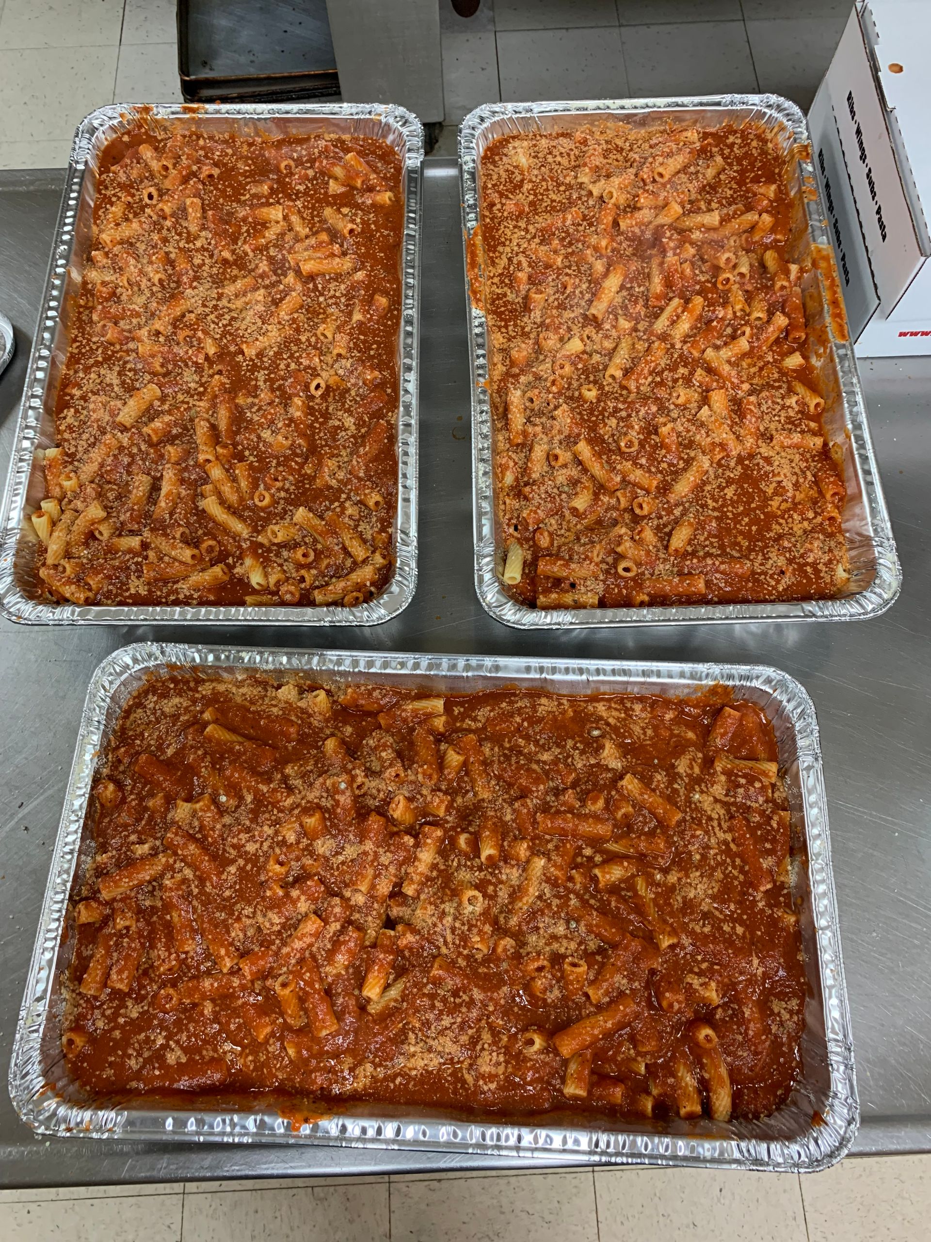 Three pans of lasagna are sitting on a counter.