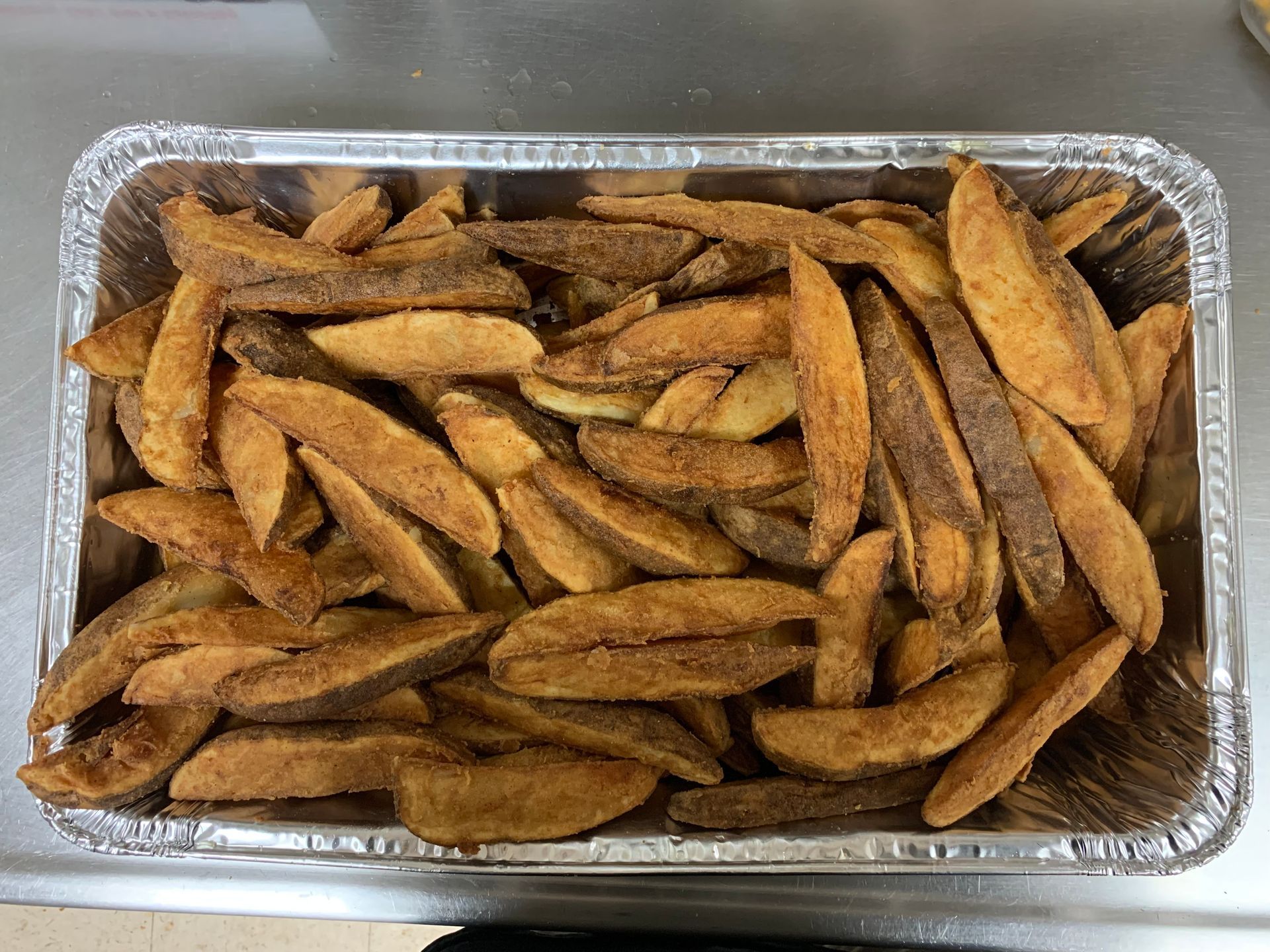 A tray of french fries is sitting on a counter.