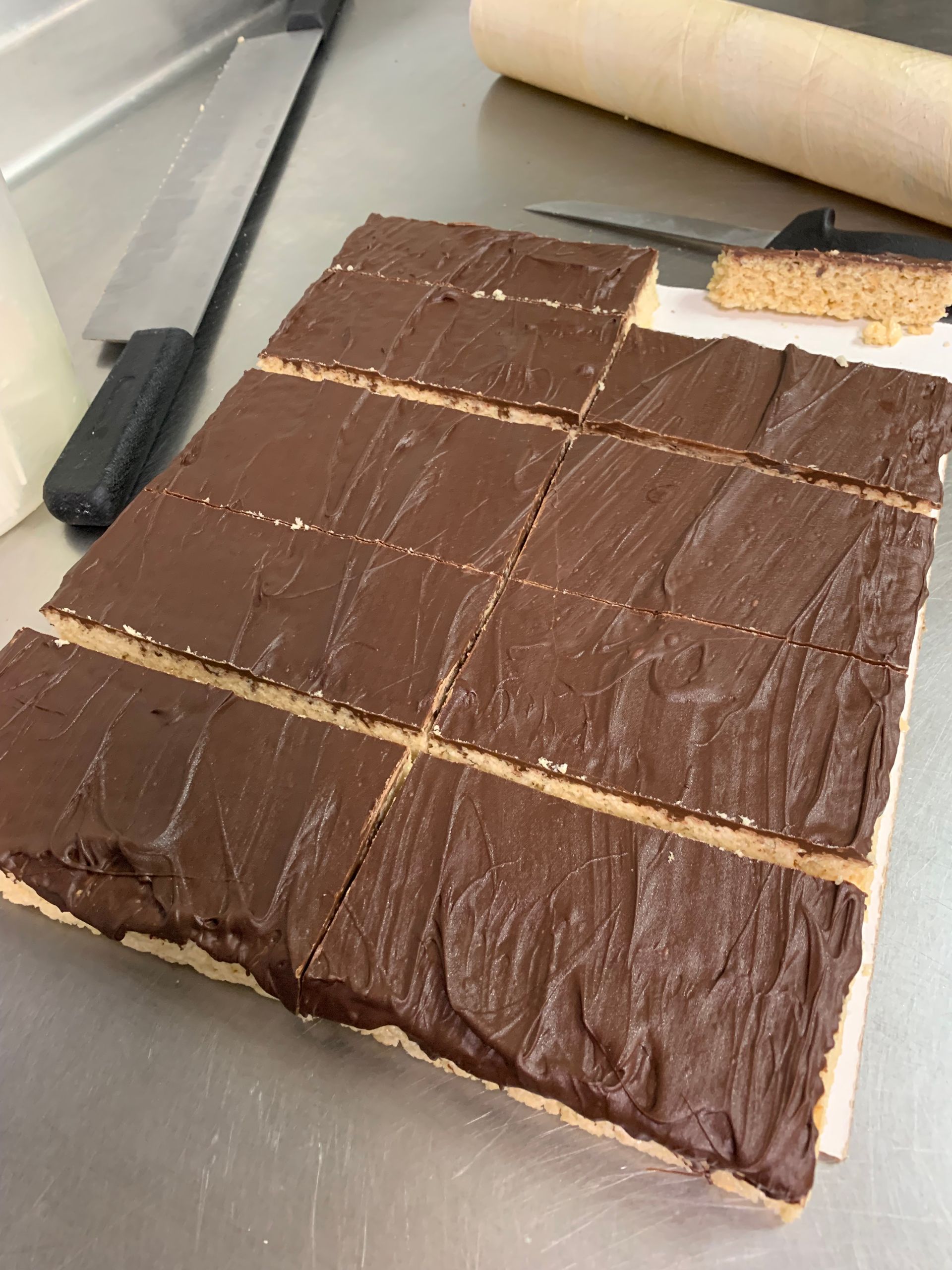 A piece of chocolate cake is cut into squares on a table