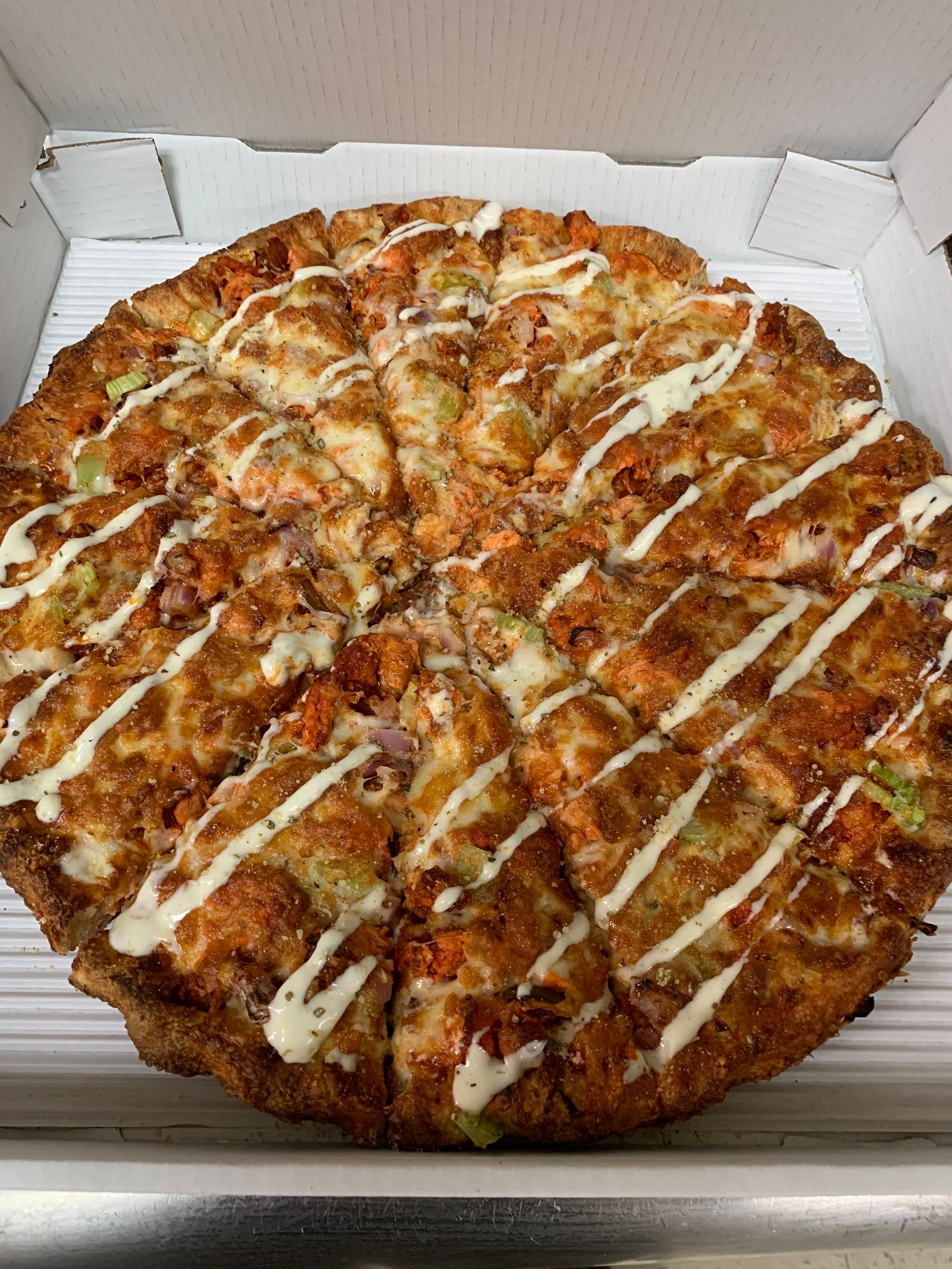 A pizza with a lot of toppings on it is in a box.