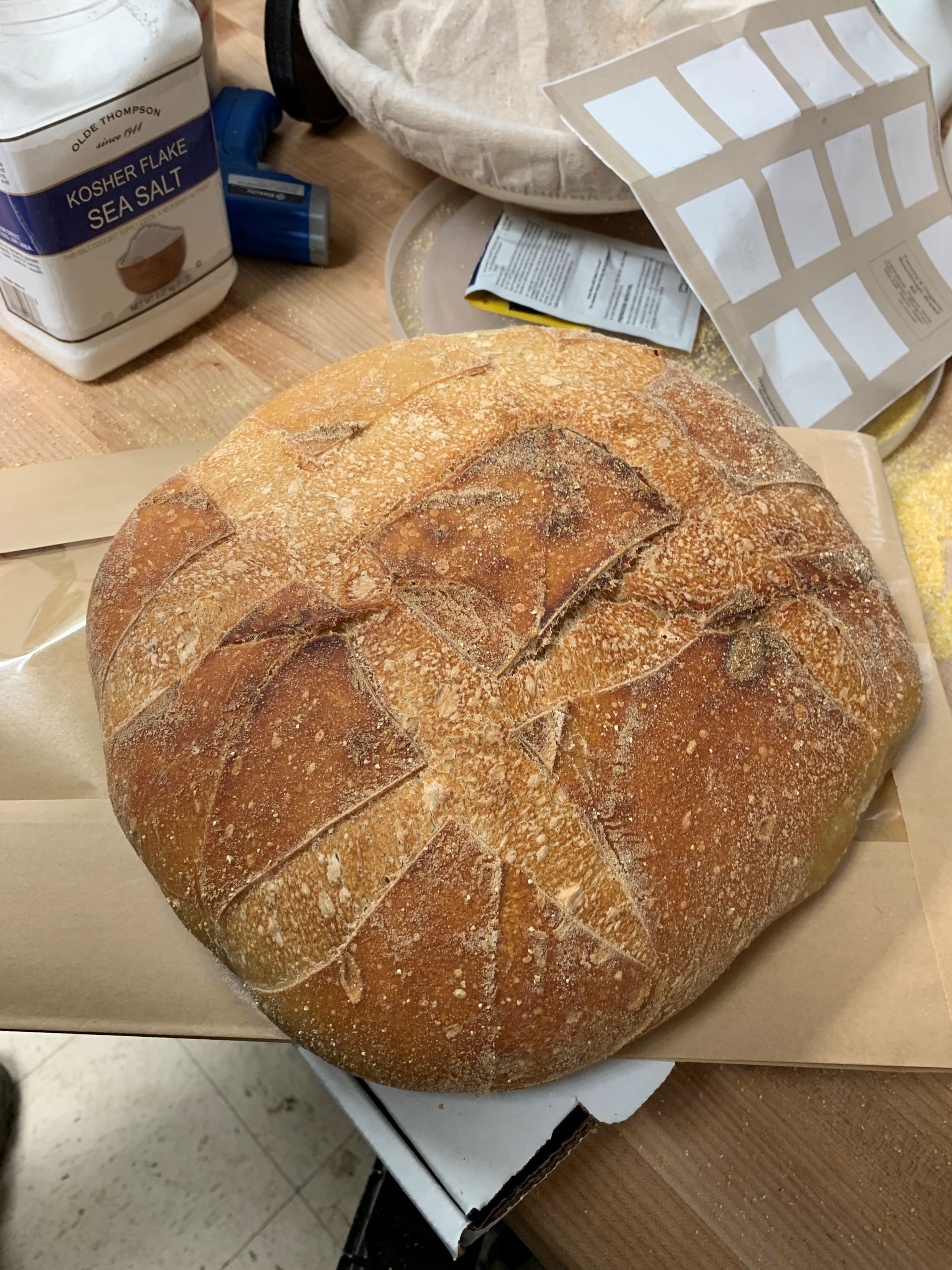 A loaf of bread is sitting on a piece of paper on a table.