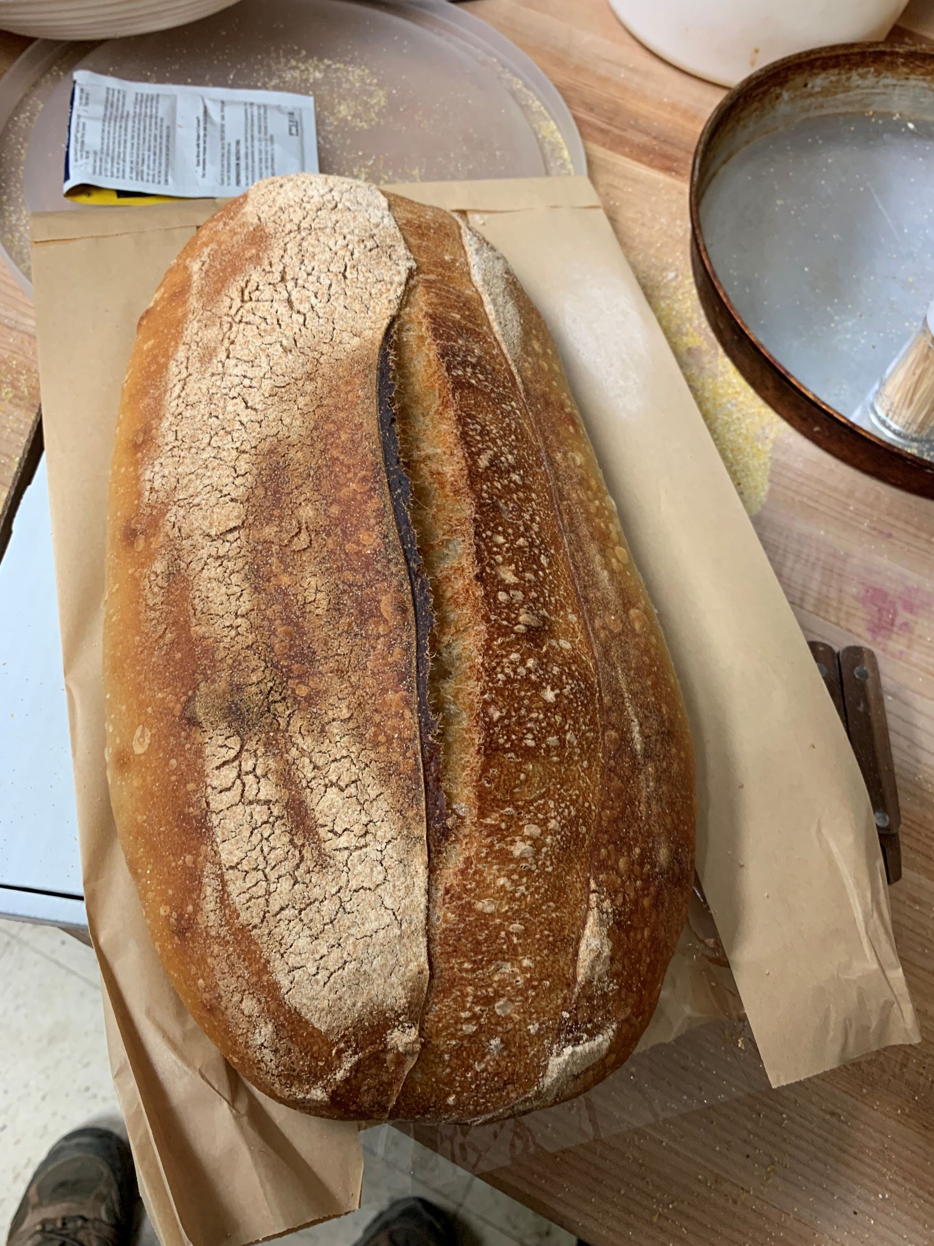 A black crate filled with bread wrapped in brown paper