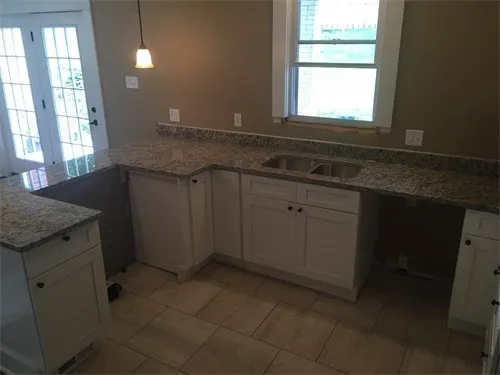 Kitchen with white cabinets, granite countertops, and a window above the sink.