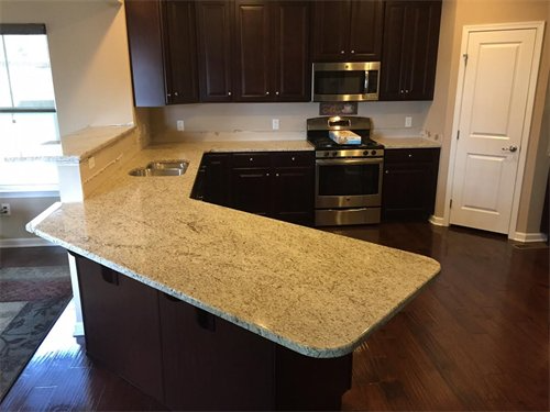 Kitchen with granite countertops, dark brown cabinets, and stainless steel appliances.