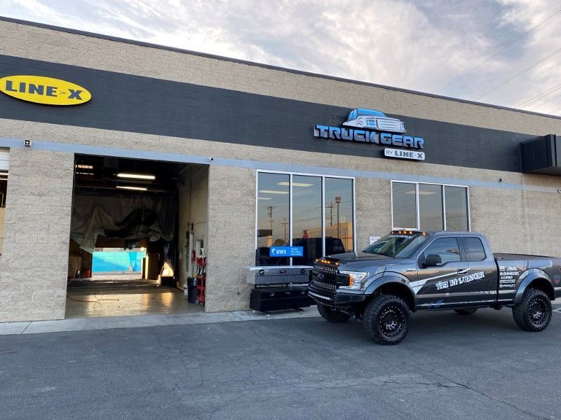 A truck is parked in front of a building that says truck gear