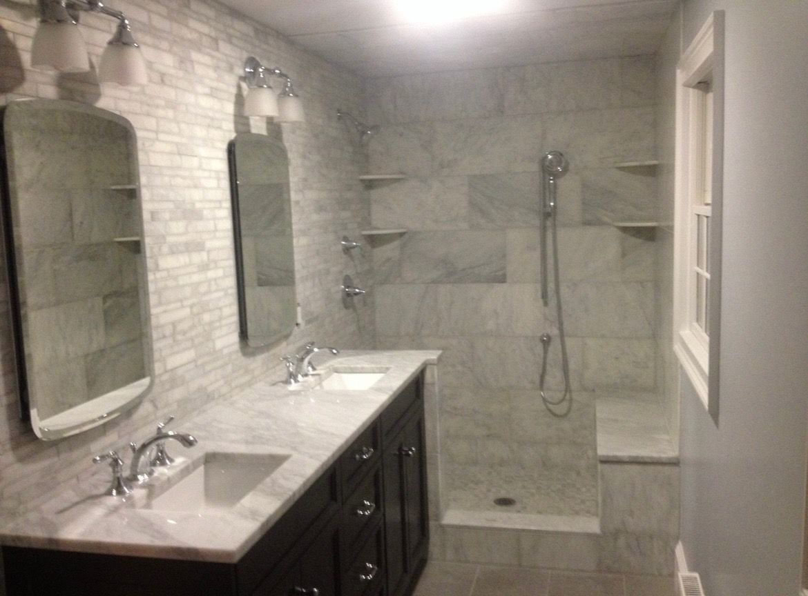 A bathroom with two sinks and a walk in shower