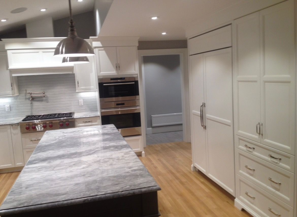 A kitchen with a large island and white cabinets