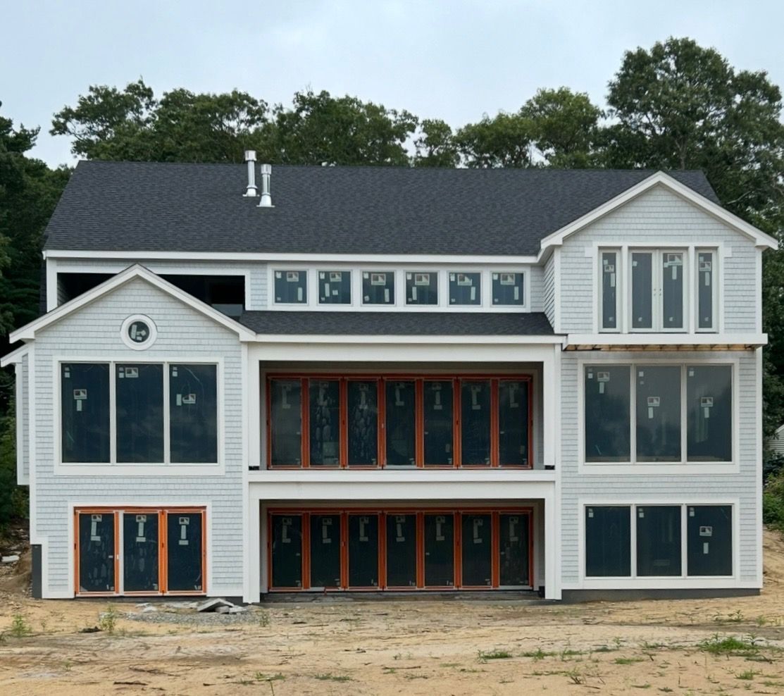 A large white house with a black roof and lots of windows