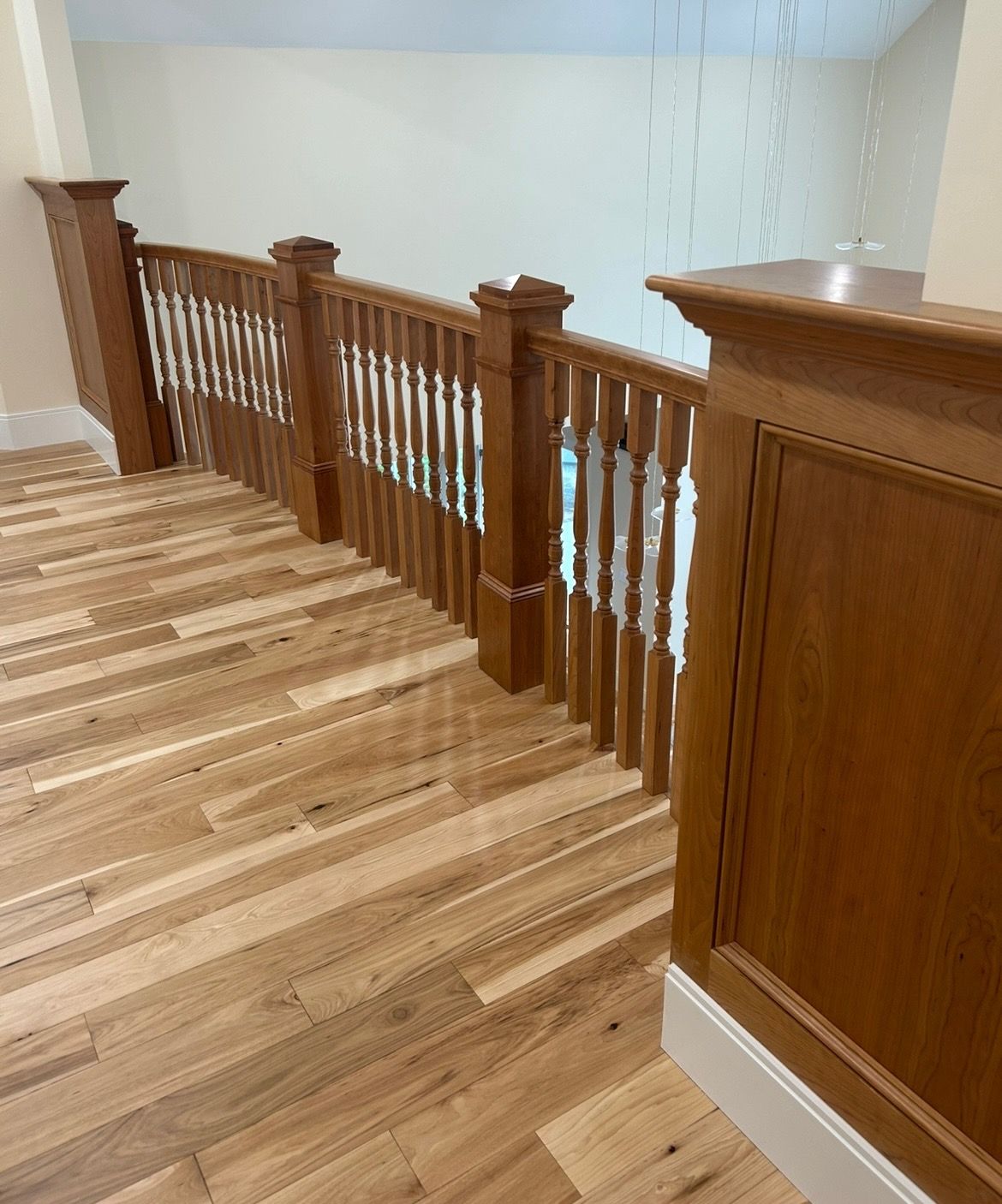 A wooden staircase with a wooden railing and a wooden floor.
