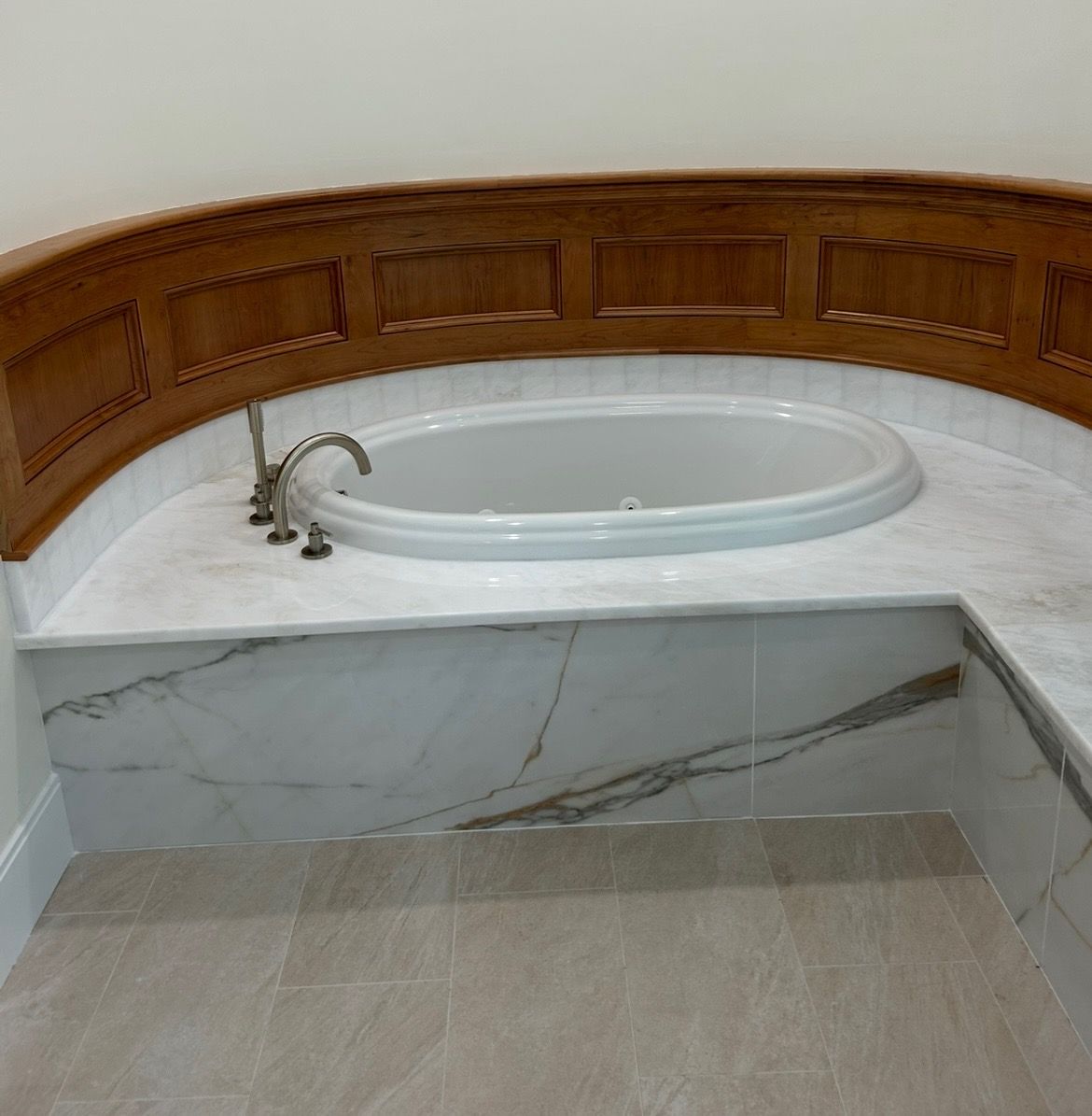 A bathtub is sitting on top of a marble counter in a bathroom