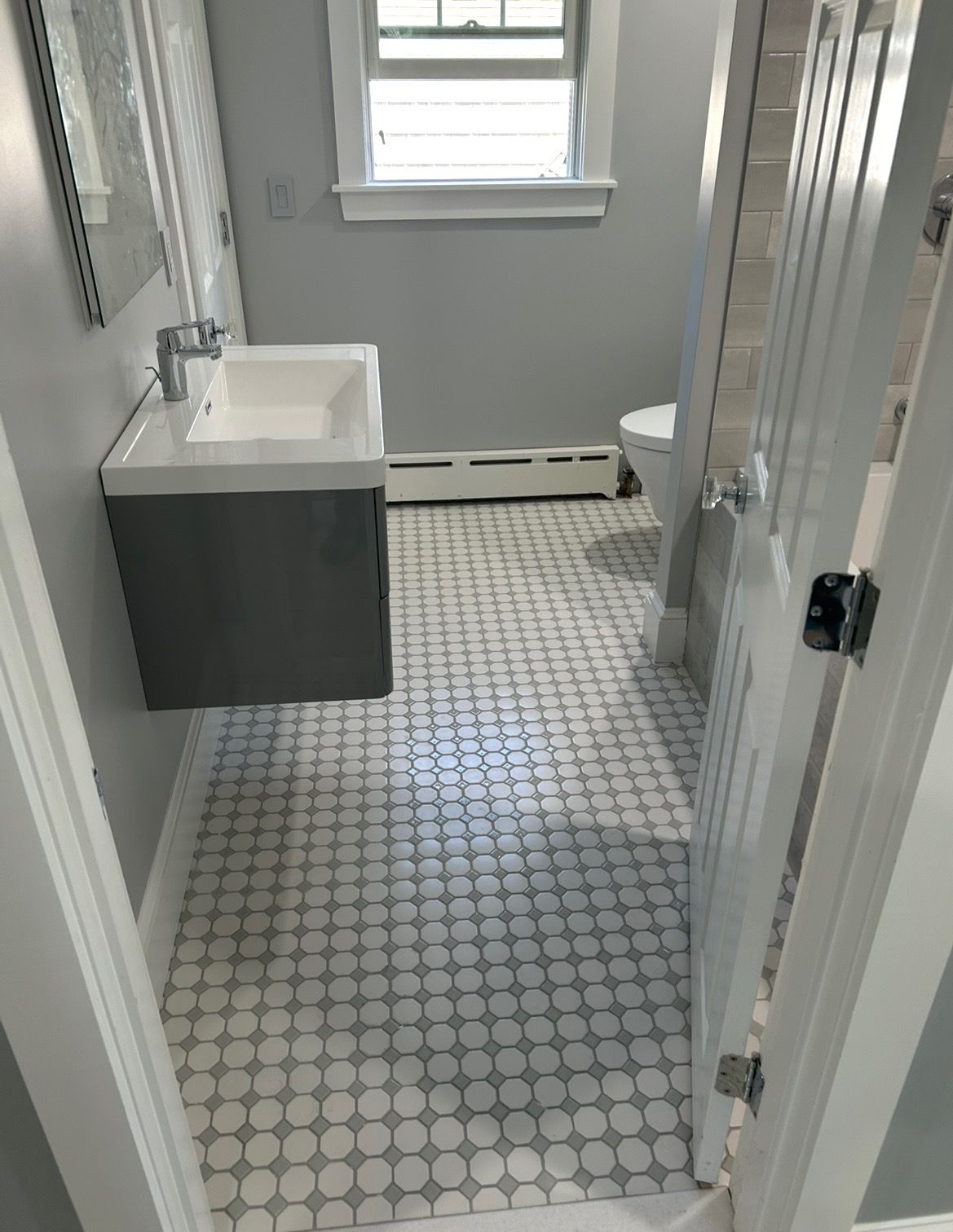 A bathroom with a sink , toilet and mirror.