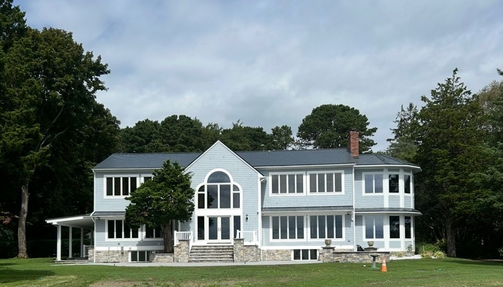 A large house with a lot of windows is surrounded by trees